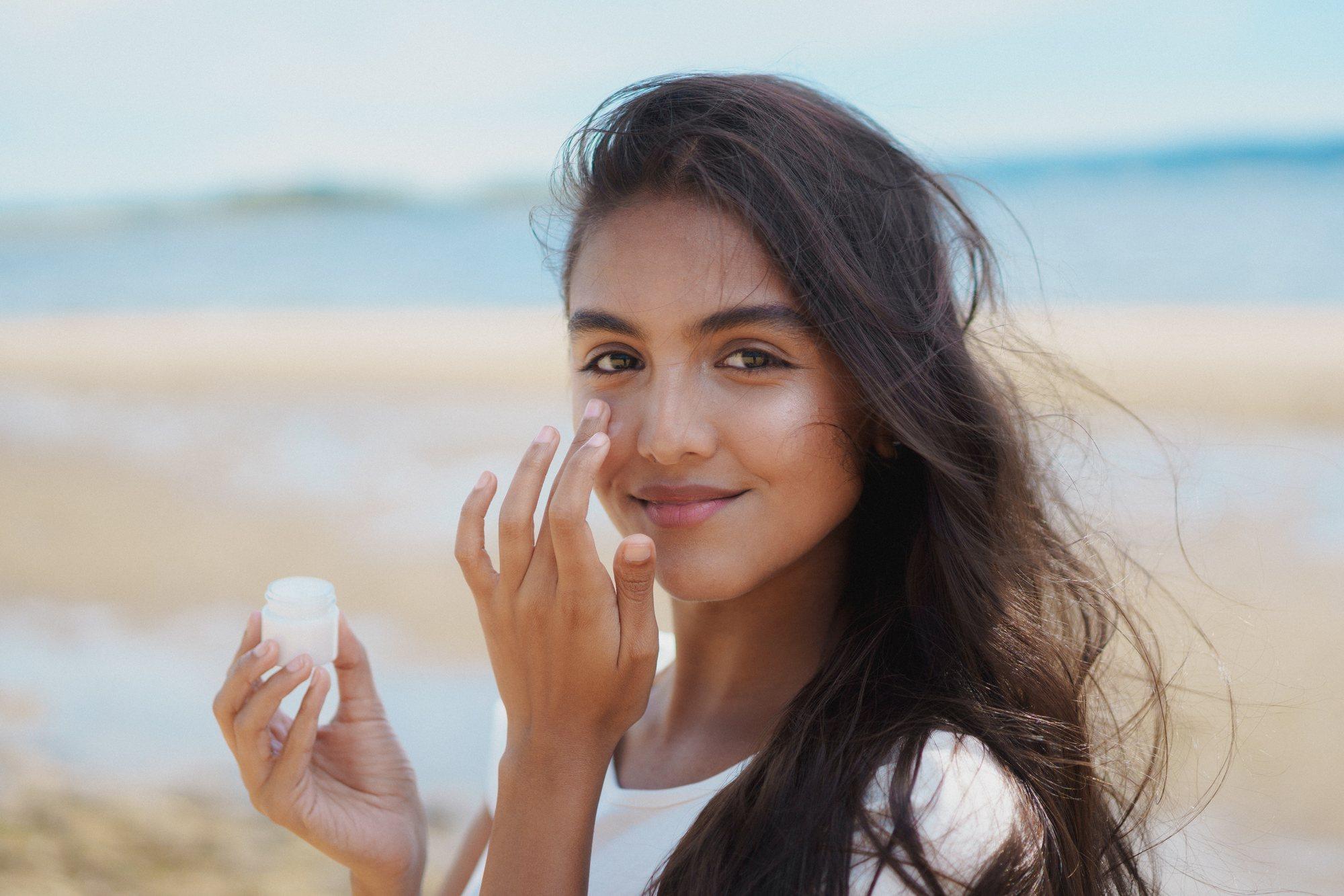 A model applying cream on the beach